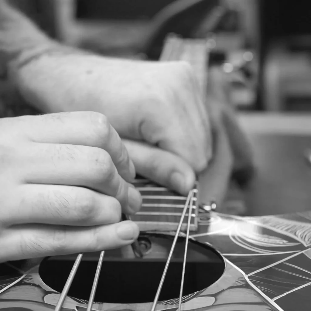 Lindo technician checking string height on a Sahara bass