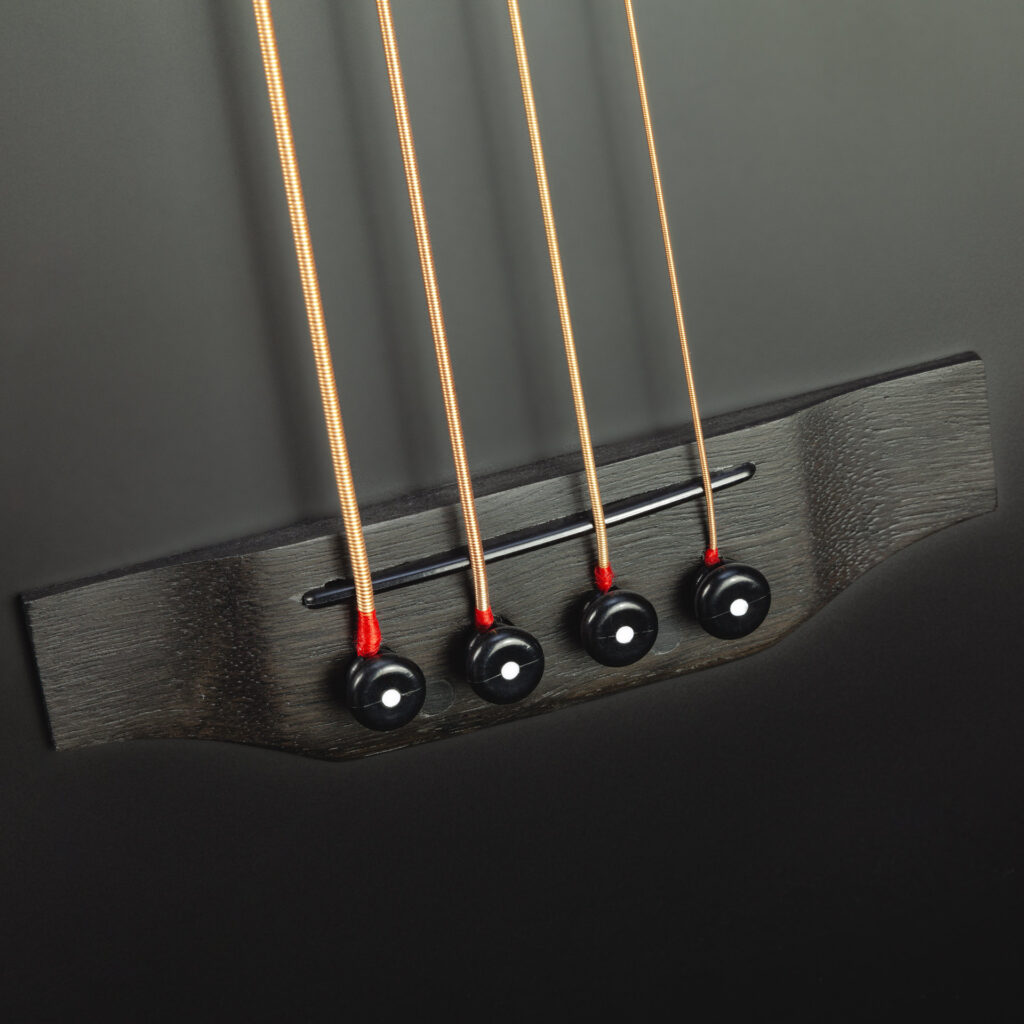Dark-dyed maple bridge and four bass strings
