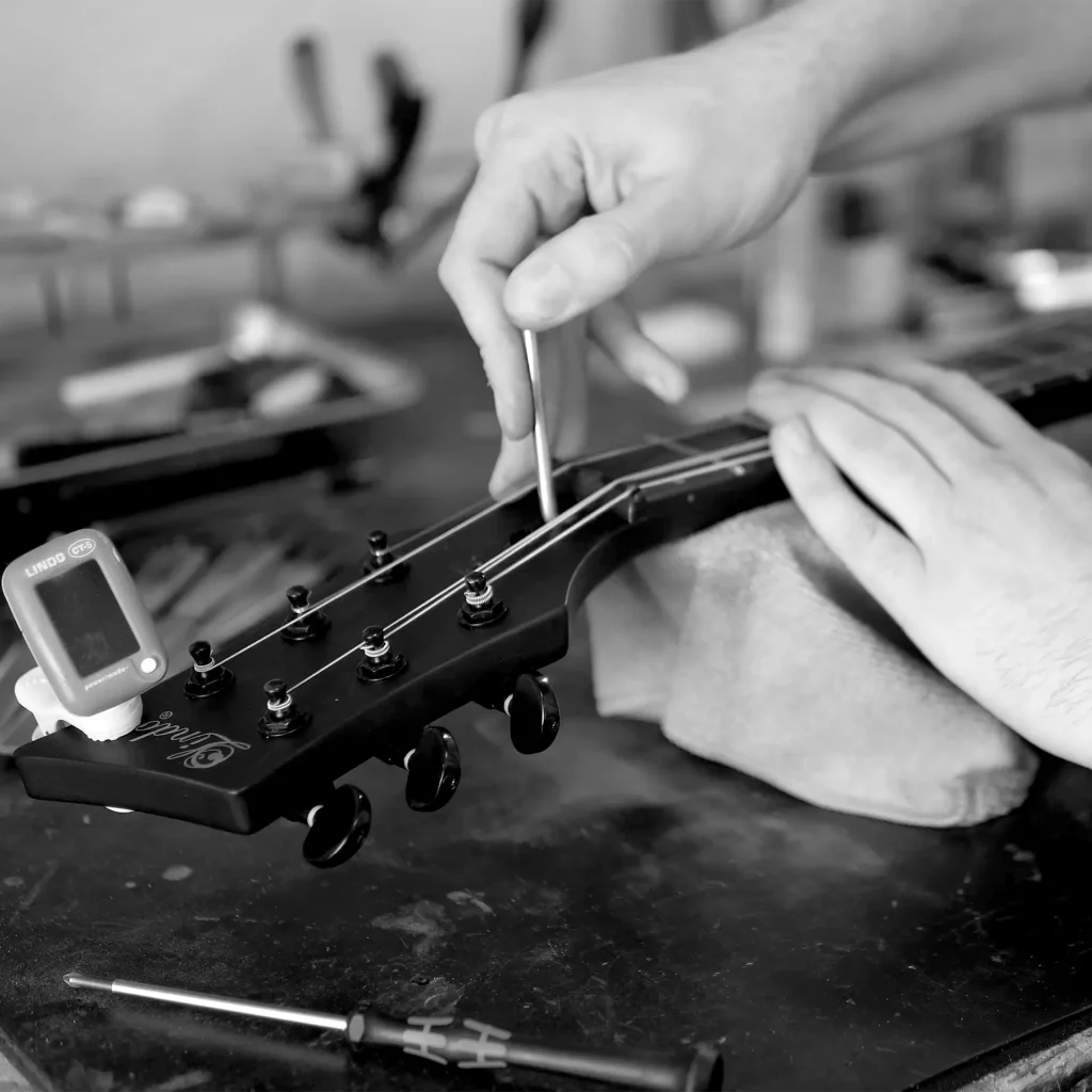 Lindo technician adjusting a Neptune guitar in the workshop