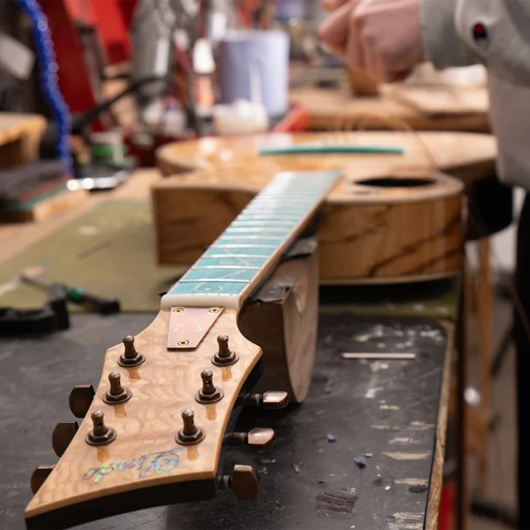 Preparing a Lindo Earth V2 guitar at the workbench
