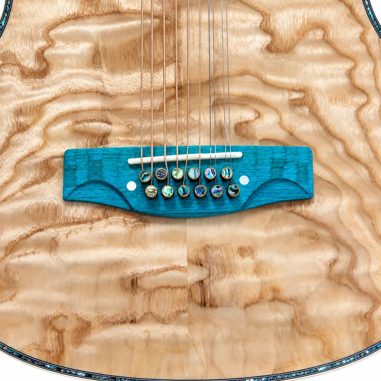 Teal composite twelve-string bridge with bone saddle and twelve brass abalone-dot bridge pins